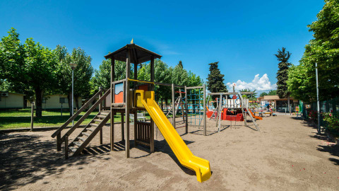 Speelplein met glijbaan en speelinfrastructuur in vakantiepark Campeggio Gasparina, Veneto, Italië.