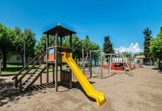 Speelplein met glijbaan en speelinfrastructuur in vakantiepark Campeggio Gasparina, Veneto, Italië.