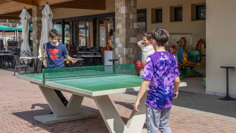 Niños juegan al tenis de mesa al aire libre en Campeggio Gasparina, un parque vacacional en Véneto, Italia.