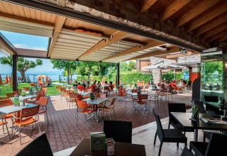 Terrasse extérieure du Campeggio Gasparina, parc de vacances en Vénétie, Italie, avec vue sur le lac.