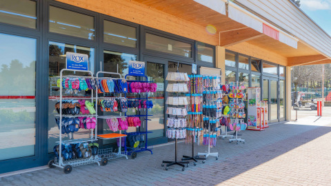 Fachada de tienda en Campeggio Gasparina, Veneto, Italia, con sandalias y artículos de vacaciones al aire libre.
