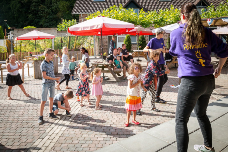 Kinder machen bei einer animierten Outdoor-Aktivität im Ferienpark Camping 't Geuldal in Limburg mit.