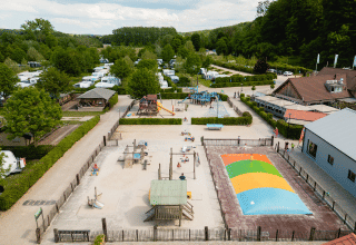 Vista aerea del Camping 't Geuldal, parco vacanze in Limburgo, Paesi Bassi, con parco giochi e campeggiatori.