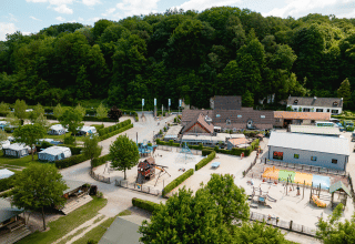 Vista aerea di Camping 't Geuldal in Limburgo, Paesi Bassi, con tende, aree gioco e alberi verdi.