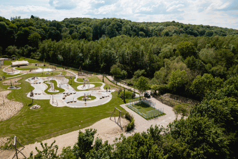 Vista aerea di un parco giochi immerso nel verde al Camping 't Geuldal, parco vacanze in Limburgo, Paesi Bassi.
