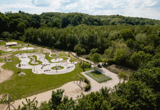 Vista aerea di un parco giochi immerso nel verde al Camping 't Geuldal, parco vacanze in Limburgo, Paesi Bassi.