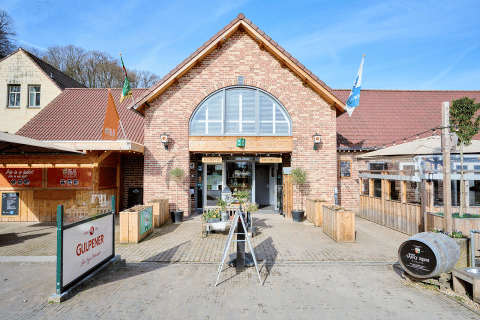 Entrance of Camping 't Geuldal holiday park in Limburg, Netherlands, with outdoor seating and visible signage.