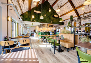 Licht en modern restaurantinterieur op Camping 't Geuldal in Limburg, Nederland met groene en houten accenten.