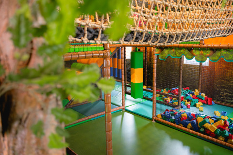 Parque infantil cubierto con red para escalar, bloques de espuma y zona de juegos en Camping 't Geuldal, Limburgo, Países Bajos.