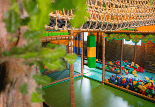 Aire de jeux intérieure avec filet d'escalade, blocs en mousse et espace de jeu au Camping 't Geuldal, Limbourg, Pays-Bas.