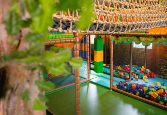Parco giochi al coperto con rete da arrampicata, blocchi di gommapiuma e area gioco al Camping 't Geuldal, Limburgo, Paesi Bassi.