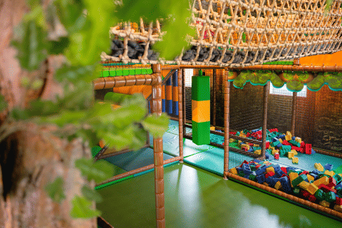 Indoor-Spielplatz mit Kletternetz, Schaumstoffblöcken und Spielbereich im Camping 't Geuldal, Limburg, Niederlande.