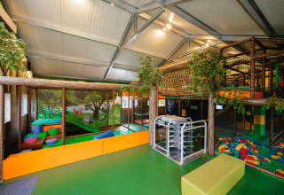 Area giochi al coperto presso Camping 't Geuldal in Limburgo, Paesi Bassi, con strutture e blocchi colorati.