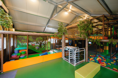 Area giochi al coperto presso Camping 't Geuldal in Limburgo, Paesi Bassi, con strutture e blocchi colorati.