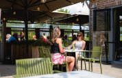 Deux femmes prennent un verre à la terrasse de Camping 't Geuldal, parc de vacances à Limbourg, Pays-Bas.