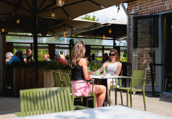 Deux femmes prennent un verre à la terrasse de Camping 't Geuldal, parc de vacances à Limbourg, Pays-Bas.