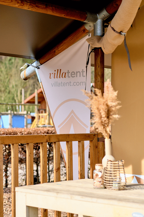 Terrazza con striscione VillaTent al Camping 't Geuldal, parco vacanze in Limburgo, Paesi Bassi.