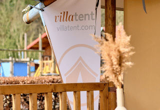 Terrazza con striscione VillaTent al Camping 't Geuldal, parco vacanze in Limburgo, Paesi Bassi.