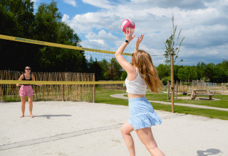 Due donne giocano a beach volley sotto il sole al Camping 't Geuldal, parco vacanze in Limburgo, Paesi Bassi.