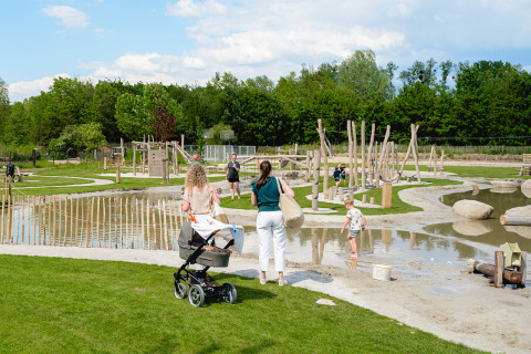 Families enjoy a sunny day at a playground in Camping 't Geuldal holiday park in Limburg, Netherlands.