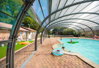 Overdækket swimmingpoolområde med familier, solbadning og børn, Camping Au Clos de La Chaume, Grand Est, Frankrig.
