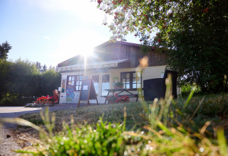 Zonnig vakantiepark met houten huisje en bloemen, vanuit laag perspectief in Grand Est, Frankrijk gefotografeerd.