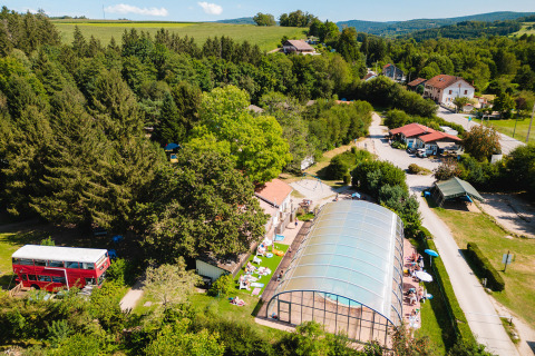 Vista aérea de Camping Au Clos de La Chaume con piscina cubierta, zonas verdes y edificios en Grand Est, Francia.