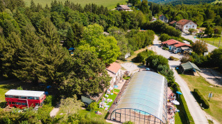 Vue aérienne du Camping Au Clos de La Chaume avec piscine couverte, arbres et bâtiments dans le Grand Est, France.