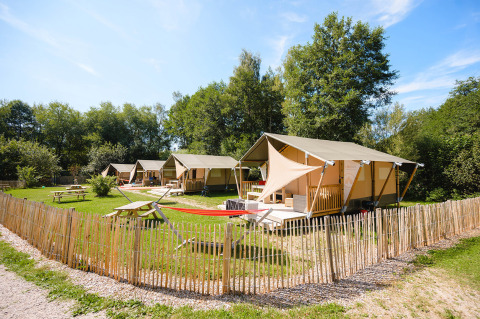 Tende glamping e tavoli da picnic al Camping Au Clos de La Chaume, parco vacanze in Grand Est, Francia.