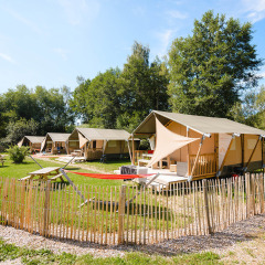 Tiendas glamping y mesas de picnic en Camping Au Clos de La Chaume, un parque de vacaciones en Grand Est, Francia.