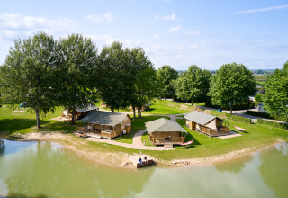 Vista aerea del Camping Betuwe, un villaggio vacanze in Gelderland, Paesi Bassi, con tende vicino al lago.