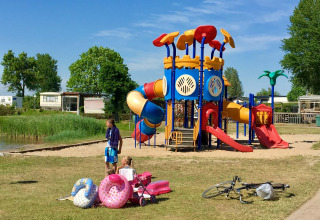 Kinderen spelen op een kleurrijke speeltuin bij Camping Betuwe, vakantiepark in Gelderland, Nederland.