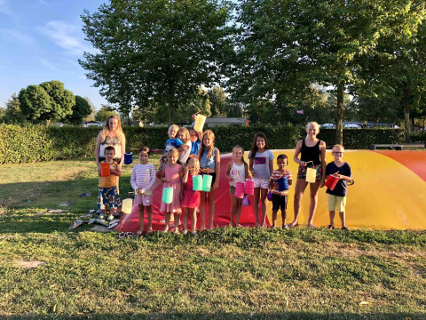 Niños y adultos con farolillos de colores en Camping Betuwe, un parque vacacional en Gelderland, Países Bajos.