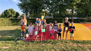 Niños y adultos con farolillos de colores en Camping Betuwe, un parque vacacional en Gelderland, Países Bajos.