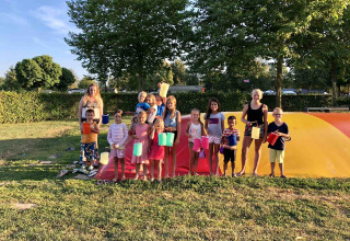 Bambini e adulti con lanterne colorate al Camping Betuwe, un villaggio vacanze in Gheldria, Paesi Bassi.