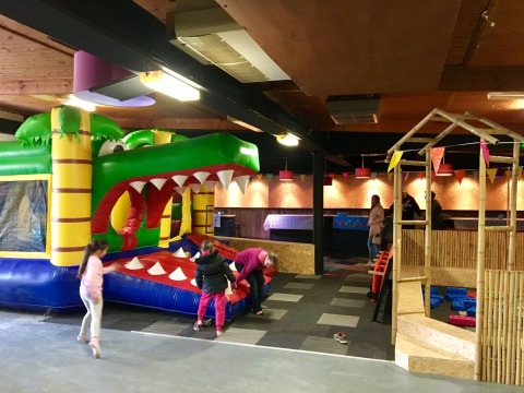 Niños juegan en parque infantil inflable cubierto en Camping Betuwe, parque vacacional en Gelderland, Países Bajos.