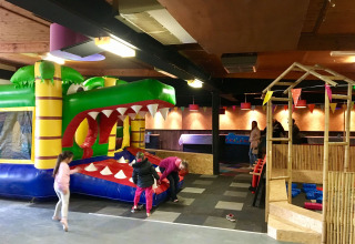 Kinderen spelen in een indoor springkasteel bij Camping Betuwe, een vakantiepark in Gelderland, Nederland.