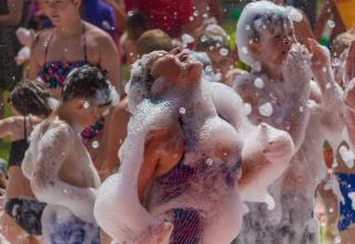 Bambini si divertono a una festa di schiuma al Camping Betuwestrand, Gelderland, Paesi Bassi.