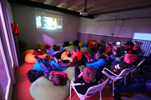 Niños ven una película en puffs en una sala común del Camping Betuwestrand, Gelderland, Países Bajos.
