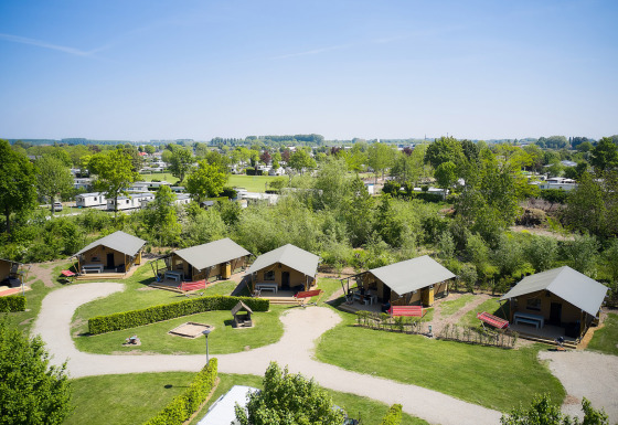 Vista aerea di Camping Betuwestrand in Gelderland, Paesi Bassi, con lodge, aree verdi e roulotte vicine.