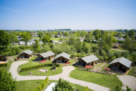 Vista aérea de Camping Betuwestrand en Gelderland, Países Bajos, con cabañas, áreas verdes y caravanas.