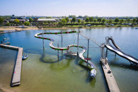 Parque acuático con toboganes curvos sobre un lago en Camping Betuwestrand, Gelderland, Países Bajos.