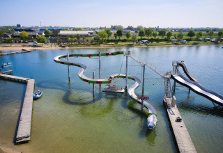 Water park with winding water slides over a lake at Camping Betuwestrand, holiday park in Gelderland, Netherlands.