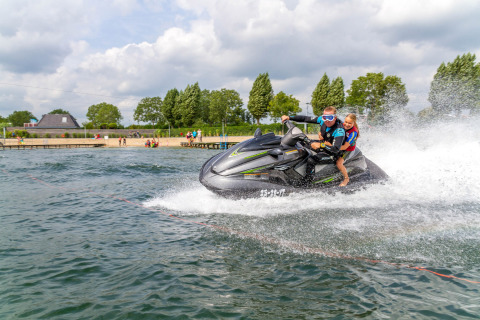 Dos personas montan en moto de agua en Camping Betuwestrand, un parque de vacaciones en Gelderland, Países Bajos.