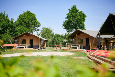 Cabañas glamping y hamacas en el verde Camping Betuwestrand, parque vacacional en Gelderland, Países Bajos.