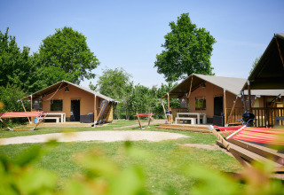 Cabañas glamping y hamacas en el verde Camping Betuwestrand, parque vacacional en Gelderland, Países Bajos.