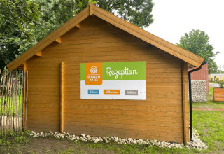 Træhytte med et skilt 'Rezeption' ved Camping Borken am See, feriested i Nordrhein-Westfalen, Tyskland.