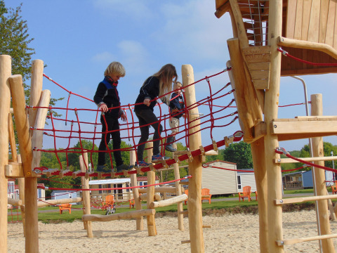 Kinder spielen auf einem Holz- und Kletterseilspielplatz im Camping Borken am See, Nordrhein-Westfalen.