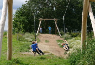 Des enfants s’amusent sur une tyrolienne au Camping Borken am See, un village vacances en Rhénanie-du-Nord-Westphalie.