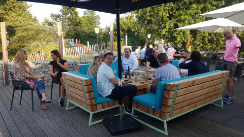 Gente disfrutando comida y bebida al aire libre en Camping Borken am See, un parque vacacional en Alemania.